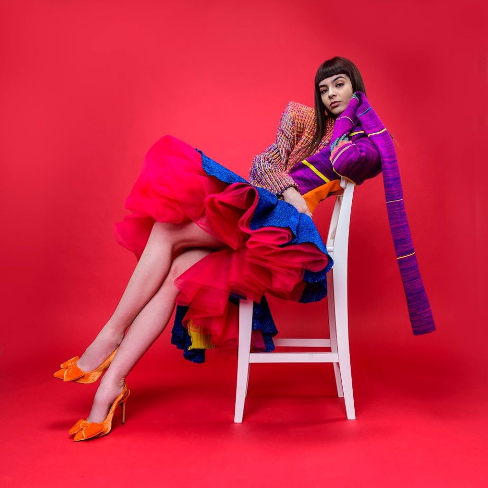 Fundal foto roșu Cherry pe fundal, cu model așezat lângă scaun