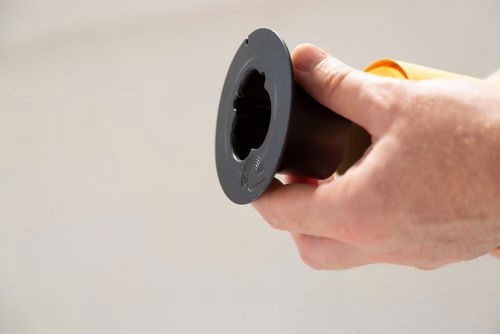 Hand holding black circular background brake/clamp with center opening