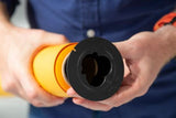 Hands holding black background brake/clamp around orange backdrop roll