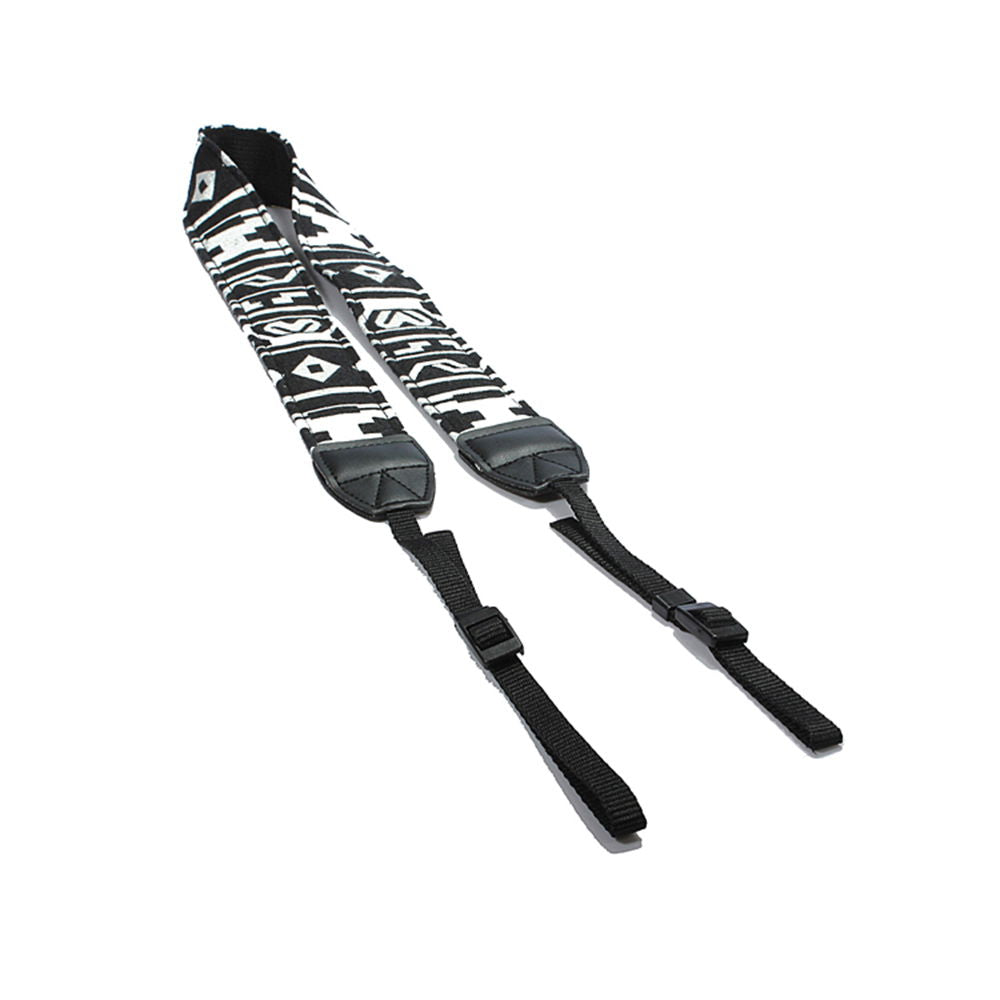 Black-and-white patterned camera strap with black leather ends and adjustable webbing