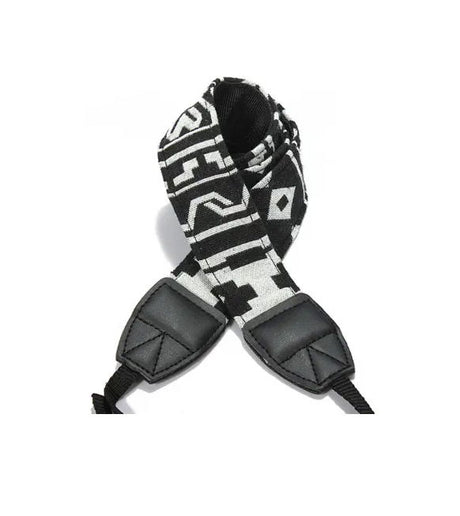 Camera strap detail with black/white patterned fabric and two black leather end pads