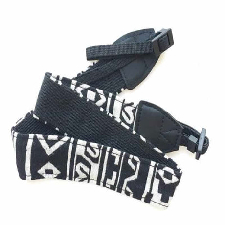 Geometric black/white camera strap with black padding and plastic buckle detail