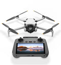 White quadcopter drone with 4 foldable propellers and black remote controller with screen