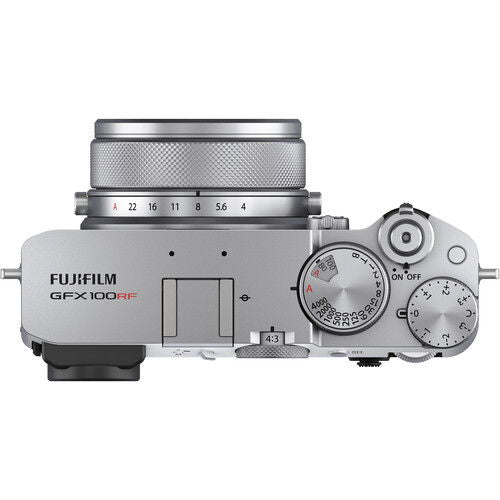 Top view of silver camera body with dials, textured grip, and lens mount