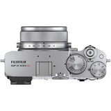 Top view of silver camera body with dials, textured grip, and lens mount