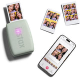Green instant photo printer beside multiple photo prints and a phone screen