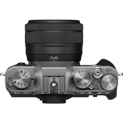 Side view mirrorless camera with 15-45mm lens; front controls and silver dials visible