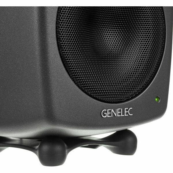 Close-up of dark gray active studio monitor woofer grille and status LED
