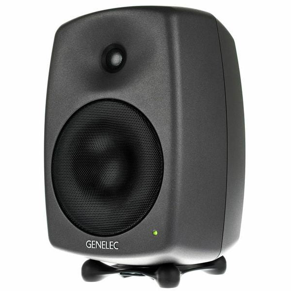 Active studio monitor speaker, front view with woofer grille and indicator light, dark gray