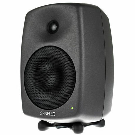 Active studio monitor speaker, front view with woofer grille and indicator light, dark gray