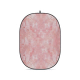 Pink textured oval foldable backdrop with black border and top hanging loop.