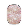 Collapsible oval photo backdrop with textured pink, cream, and tan pattern
