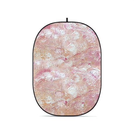 Collapsible oval photo backdrop with textured pink, cream, and tan pattern