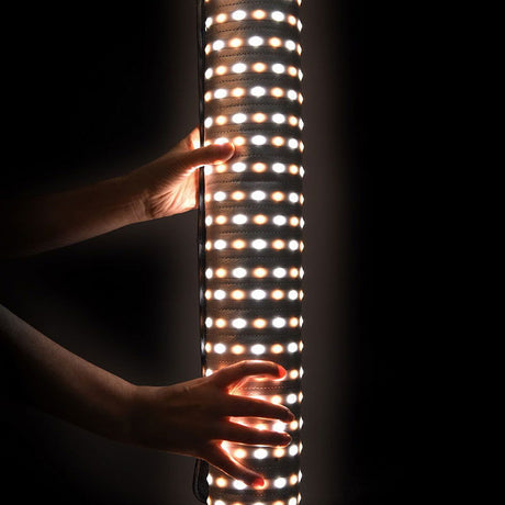 Glowing LED panel showing multiple bulb rows, handheld near the light