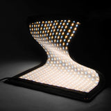 Folded LED light with curved diffuser and illuminated bulb rows on black case