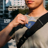 Black sling bag worn crossbody with card-slot pocket feature on front