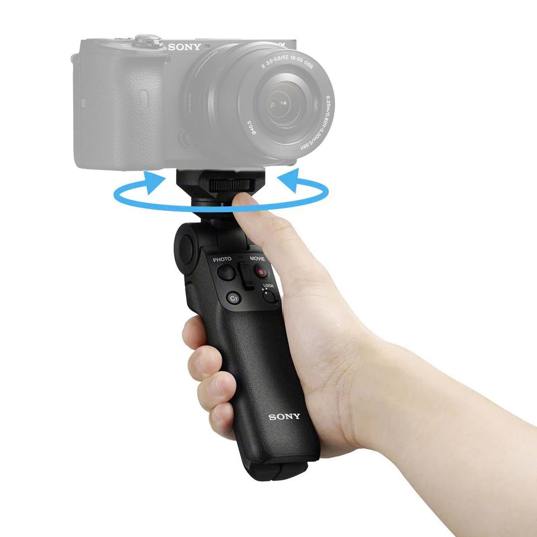 Hand holding black wireless shooting grip with photo/movie controls visible