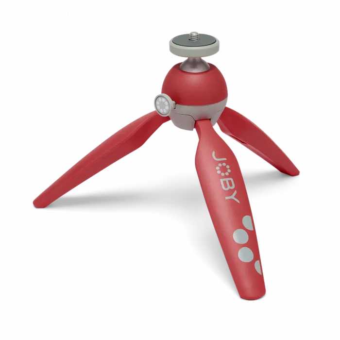 Red Joby mini tripod with three folding legs and ball head, close-up view