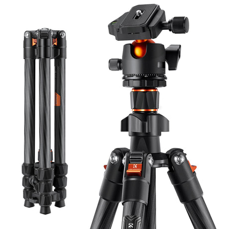 Black carbon-fiber tripod head close-up with locking dials and orange accents