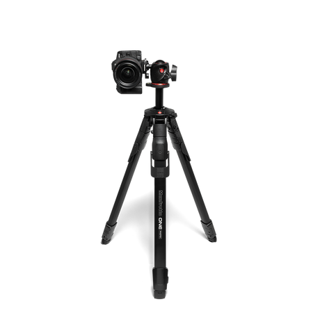 Tripod standing with a camera mounted on a black ball head, three legs visible