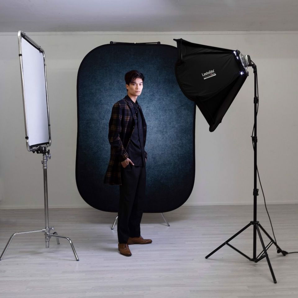 Portable two-sided backdrop set upright, dark ink blue face visible