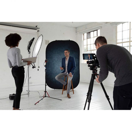 Portable backdrop standing for studio use, dark ink blue surface visible