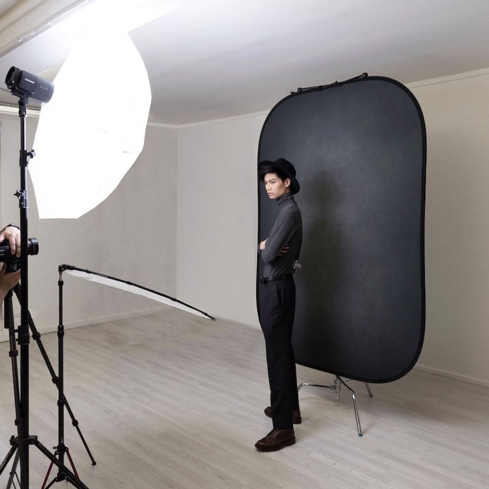 Pewter/charcoal portable photo backdrop panel on a stand in studio
