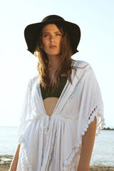 Model portrait outdoors wearing white cover-up; reflector not visible in frame