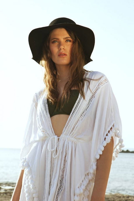 Model portrait outdoors wearing white cover-up; reflector not visible in frame