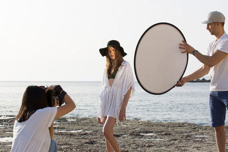 Circular 95cm reflector with beige inner and silver backup, open and held by handle