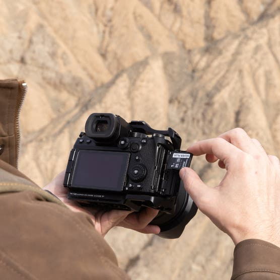 Camera held in hands with SD card inserted