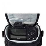 Open black camera bag showing a mounted digital camera with display and button controls