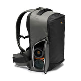 Gray camera backpack side view with open compartments holding two camera lenses