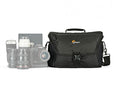 Black camera bag with top handle, front flap, and shoulder strap; front buckle pocket.