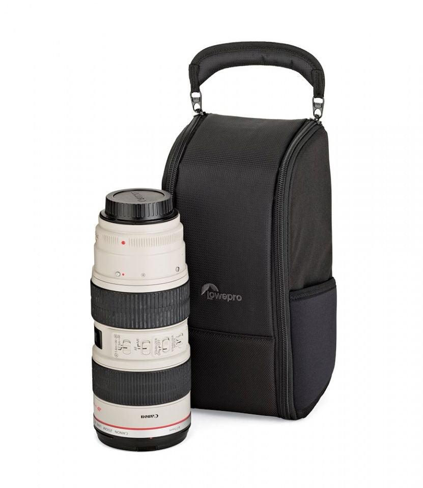 Black upright camera bag with top handle and zipper; holds a white camera lens