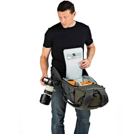 Olive and gray photo backpack worn, front compartment open with camera gear inside