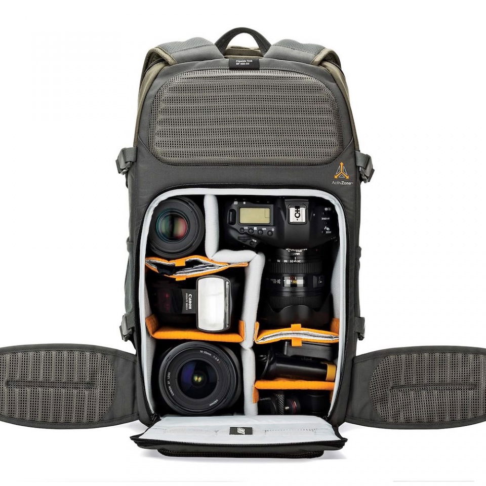 Open camera backpack showing lenses and camera bodies in padded compartments
