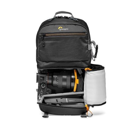 Black camera backpack open showing lens compartment and white storage sleeve