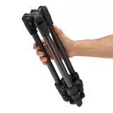 Tripod legs held by hand, showing locking knobs and pan head on top