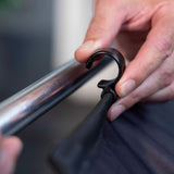 Hand fastening the backdrop fabric to the frame with a strap clamp