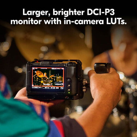 Compact cinema camera with rear monitor displaying a colorful video scene, black