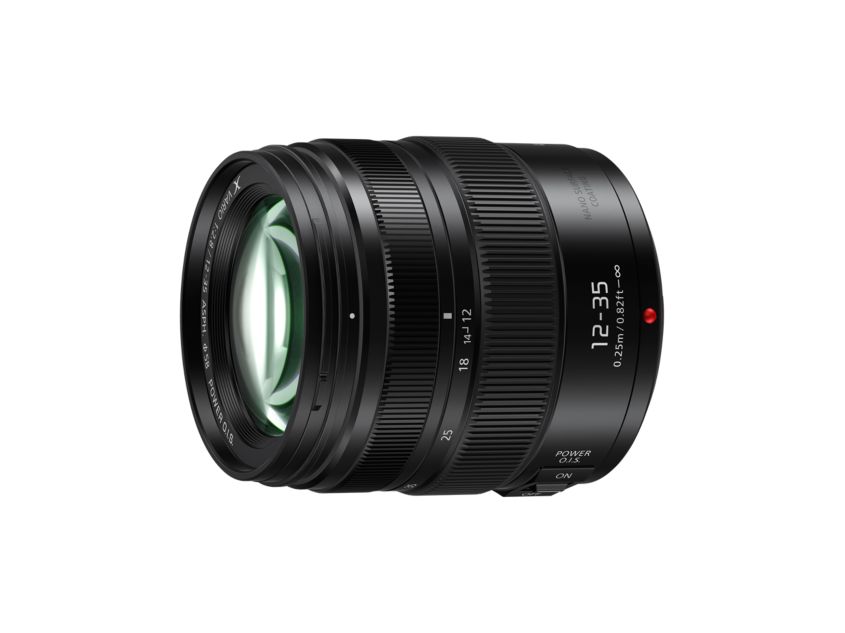 Angled view of black 12-35mm f/2.8 lens with textured zoom rings and front element