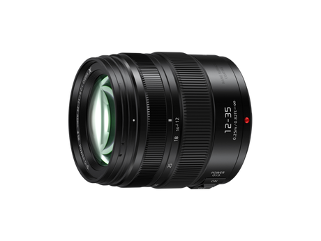 Angled view of black 12-35mm f/2.8 lens with textured zoom rings and front element