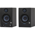 Black studio monitor speaker with blue-lit controls and front tweeter/woofer grilles.