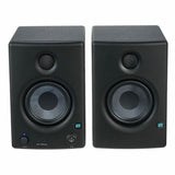 Front view of two black studio monitor speakers with circular drivers and controls