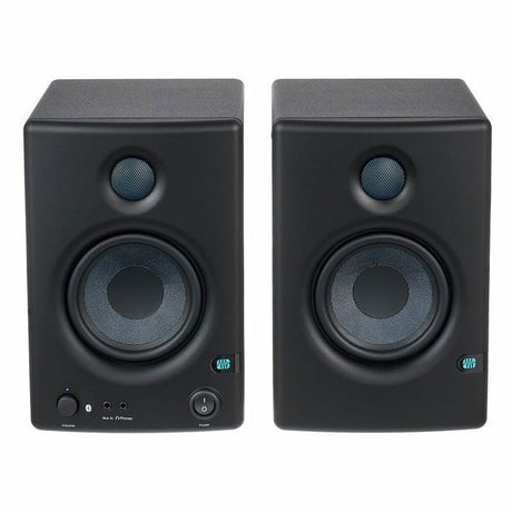 Black studio monitor speakers front view, volume and input controls on lower panel