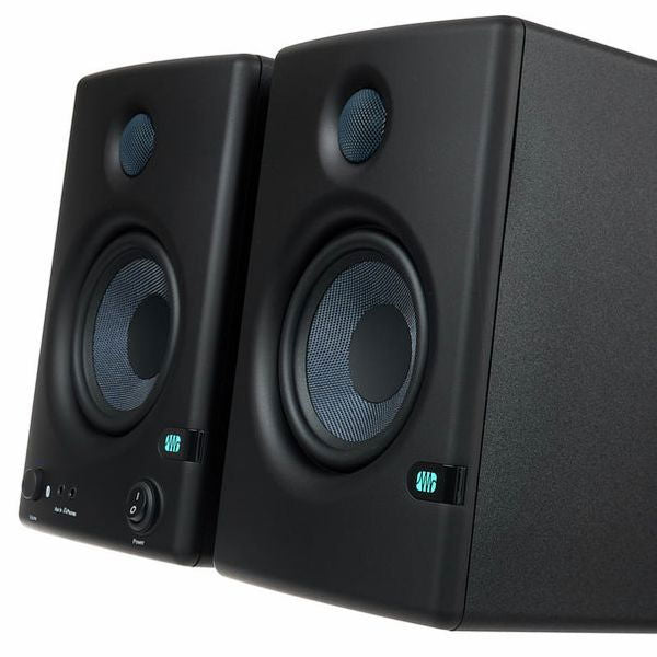 Angled close view of black studio monitor speakers, tweeter and woofer detail