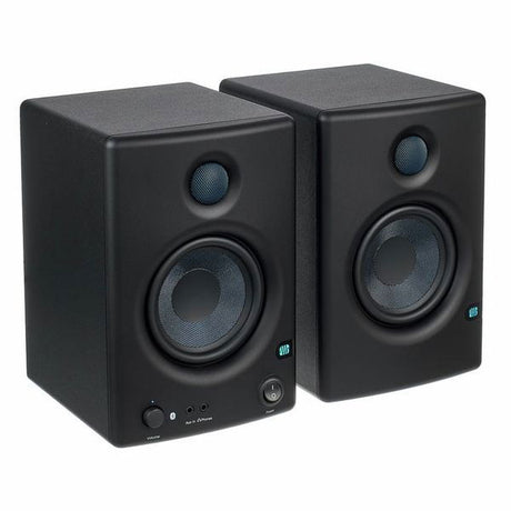 Studio monitor speakers in angled view, front tweeter and woofer drivers visible
