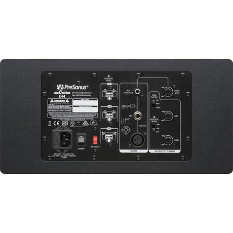 Studio monitor speaker rear panel with ports and input controls, dark cabinet