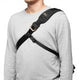 Black camera bag across chest with wide padded strap and top flap